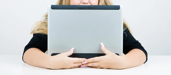 Flickan gömmer sig bakom en laptop — Stockfoto