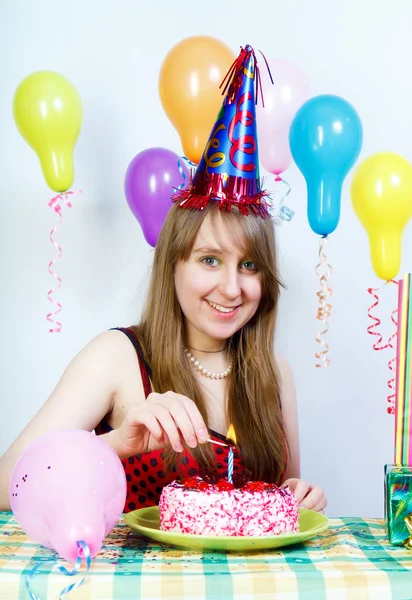Birthday. Happy attractive girl lights a candle — Stock Photo, Image