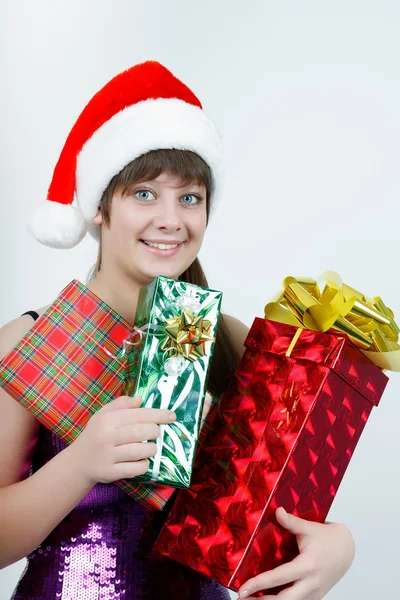 Attractive girl in a Christmas hat with gift boxes — Stock Photo, Image