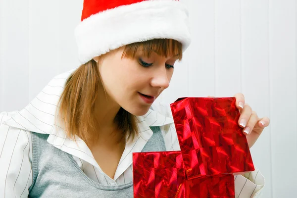 Attractive girl opens a Christmas present — Stock Photo, Image