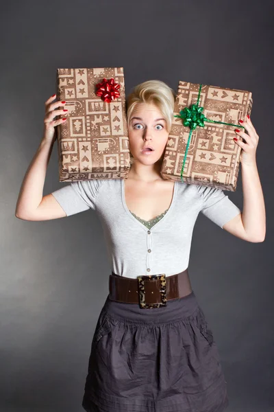 Surprised pretty woman holding two gift box