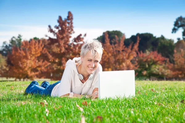 Usmívající se dívka použití notebooku venku. — Stock fotografie