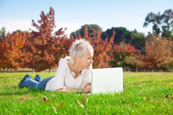 Smiling girl using laptop outdoors. — Stock Photo, Image