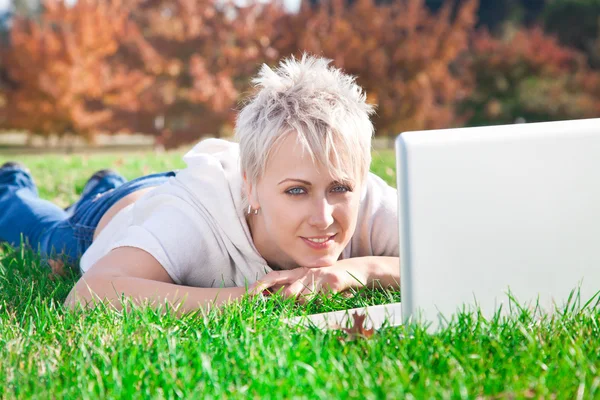 Smiling girl using laptop — Stock Photo, Image