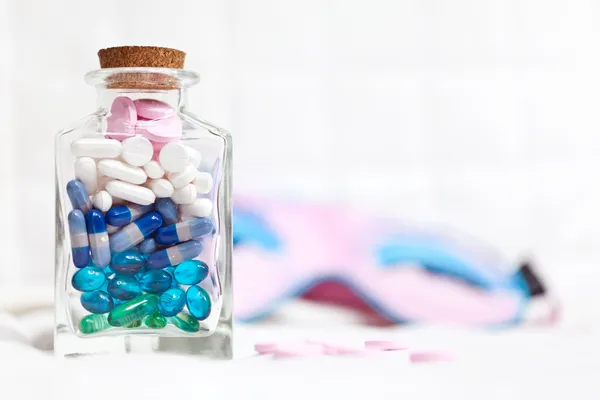 Pillole assortite in una bottiglia di vetro Fotografia Stock