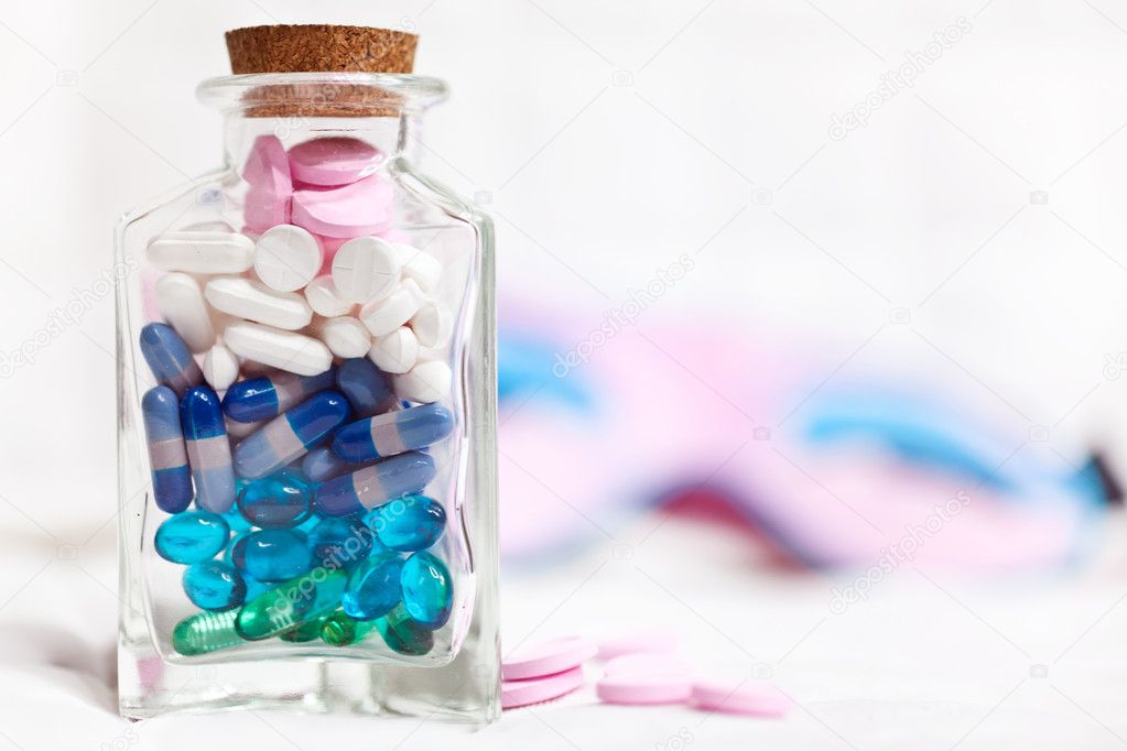 Assorted pills in a glass bottle