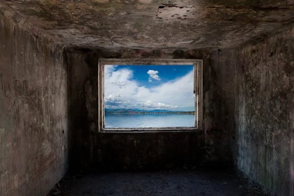 Vieille chambre sombre avec fenêtre avec mer derrière lui — Photo