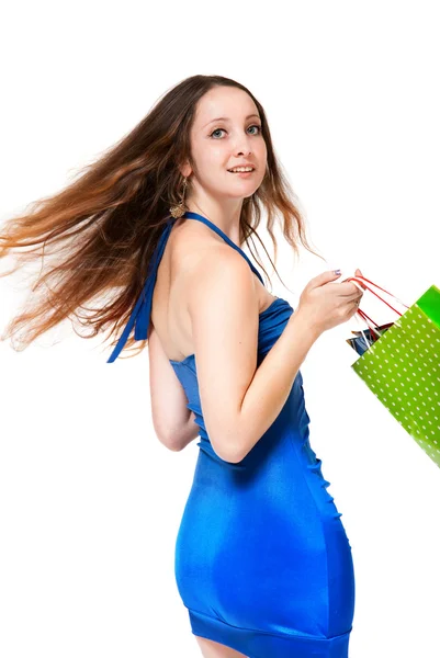 Młoda kobieta w niebieska sukienka z kolorowe torby na zakupy na biały — Zdjęcie stockowe