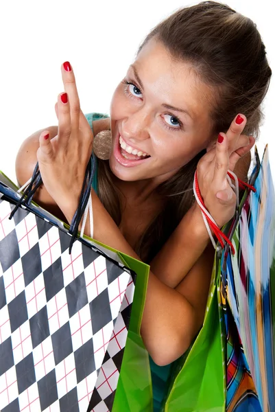 Jonge vrouw met kleurrijke boodschappentassen in handen op een witte achterzijde — Stockfoto