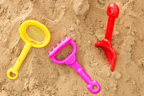 在沙滩上的彩色塑料玩具 — 图库照片