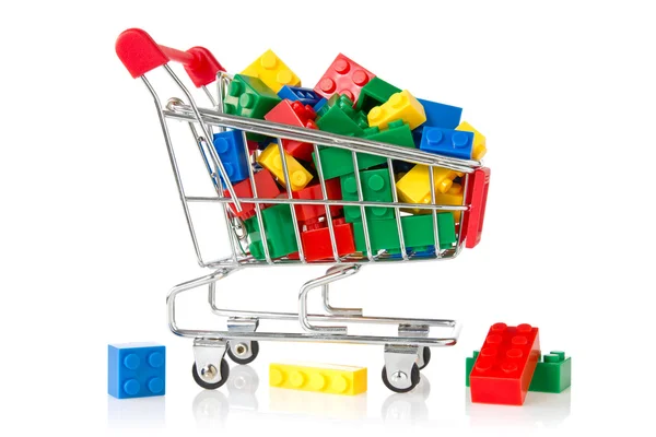 Ladrillos de plástico de color en un carrito de compras — Foto de Stock