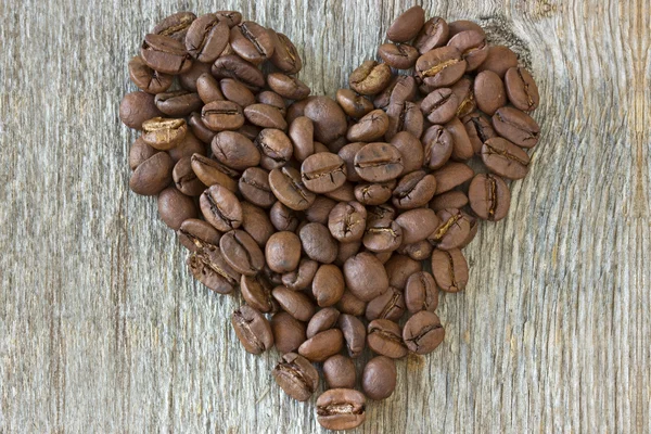 stock image Coffe beans heart on wood background