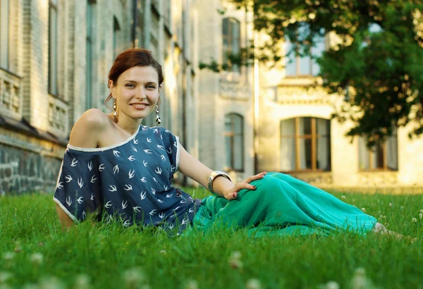 Krásná mladá žena uvolňující na zelené trávě — Stock fotografie
