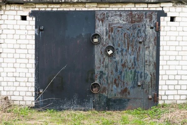 Puerta de garaje de metal negro con tres grandes cerraduras —  Fotos de Stock