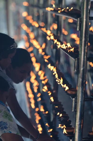 Линия светлых масляных ламп в буддийском храме — стоковое фото
