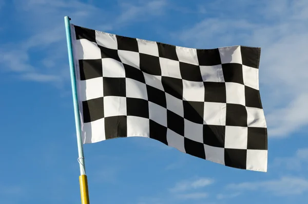 Bandeira quadriculada com céu azul — Fotografia de Stock