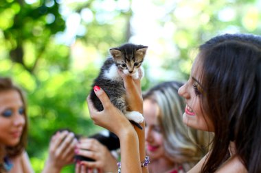 Beyaz kadınlarla oldukça genç yavru kedi