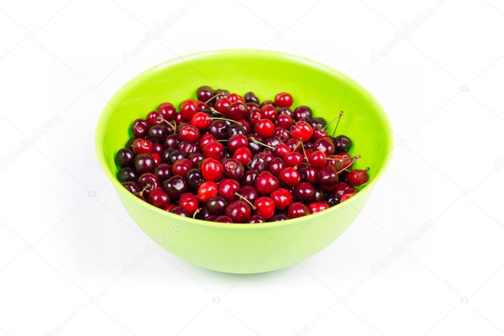Cherry in green plastic bowl isolated on white background