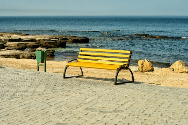 Пустая деревянная скамейка на берегу моря — стоковое фото