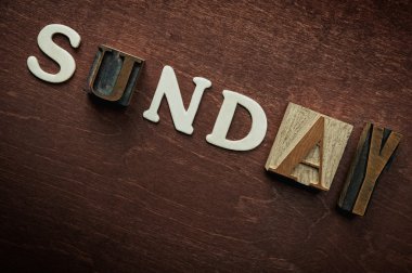 The word sunday written on wooden background clipart