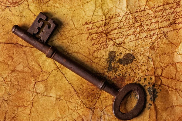 De oude sleutel op de geweven papier — Stockfoto