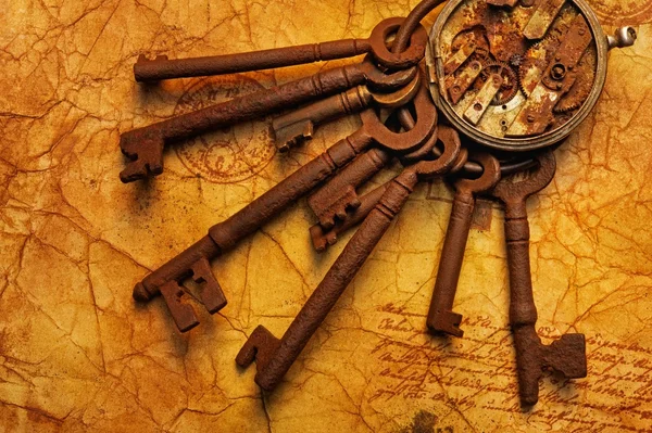 Куча ключей с шестеренками на старой текстурной бумаге — стоковое фото