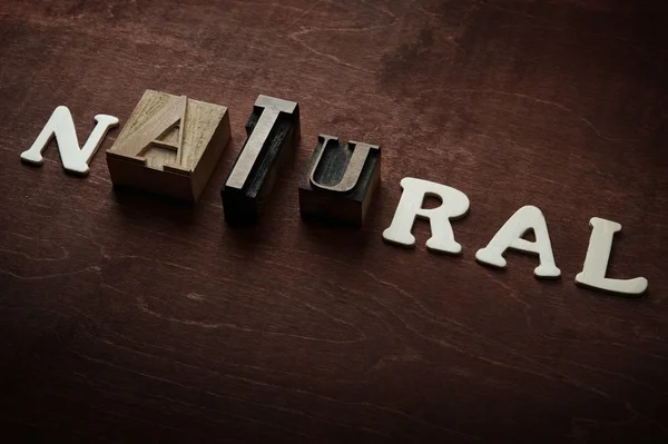 Ordet naturliga skrivet på trä bakgrund — Stockfoto
