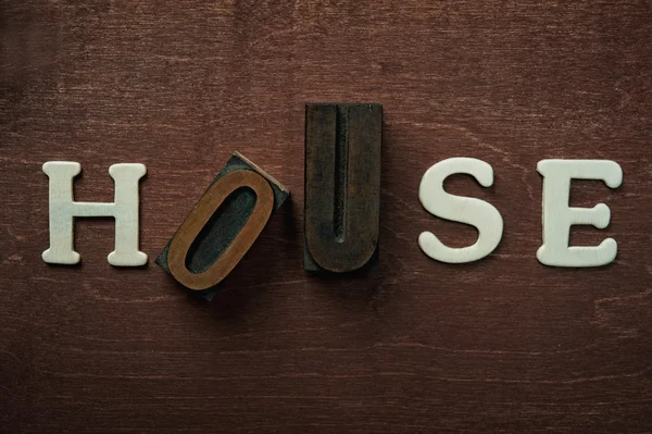 Tjhe palavra casa escrita sobre fundo de madeira — Fotografia de Stock