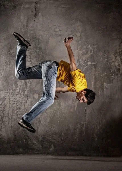 Ung man hoppa mot grunge vägg — Stockfoto