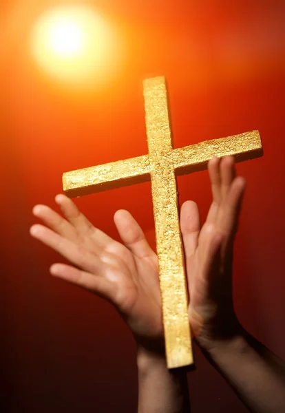 Golden cross in human hands — Stock Photo, Image
