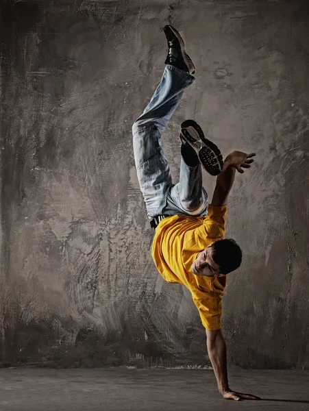 Jeune homme dansant contre un mur grunge — Photo