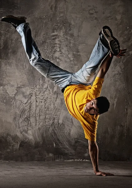 Giovane uomo che balla contro il muro grunge — Foto Stock