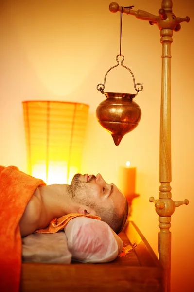 Hombre teniendo un masaje shirodhara en un salón —  Fotos de Stock