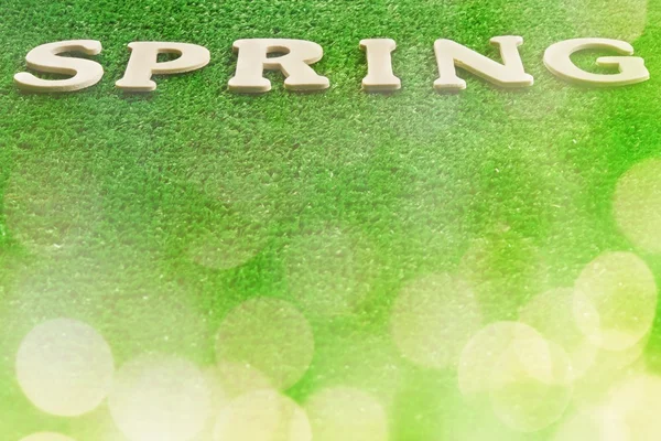 The word spring written on green background — Stock Photo, Image