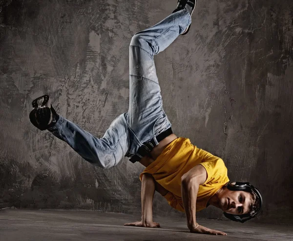 Young man dancing against grunge wall Royalty Free Stock Images
