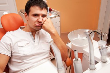 Sad patient at a dentist's surgery. clipart