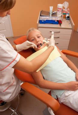 Teenage girl at the dentist. clipart