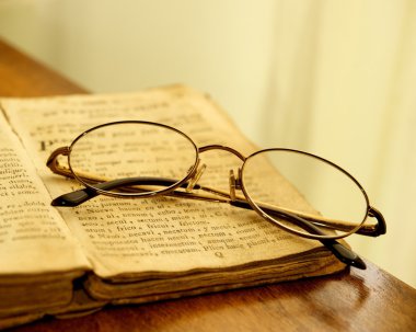 Glasses on vintage book. clipart