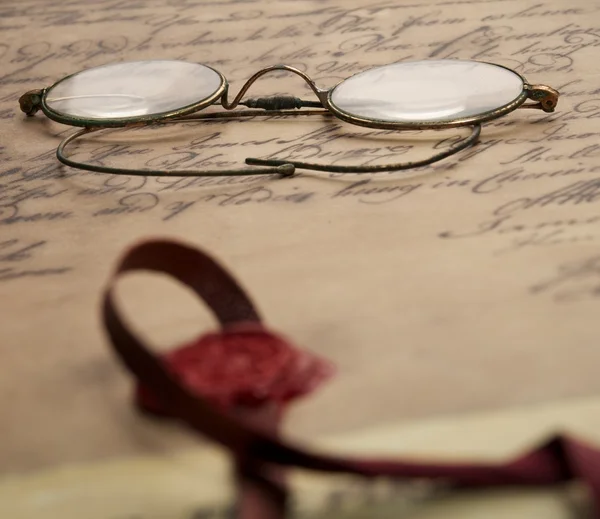 Old glasses on the vintage document — Stock Photo, Image