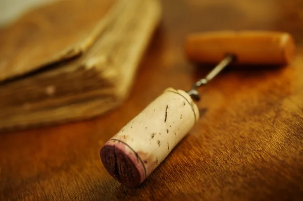 Corkscrew near a vintage book. — Stock Photo, Image