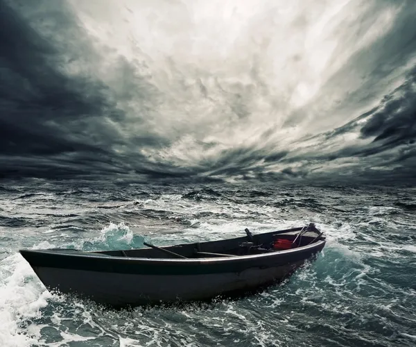 Брошенная лодка в бурном море — стоковое фото