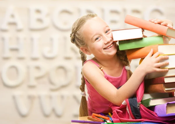 Weinig schoolmeisje met stapel boeken — Stockfoto