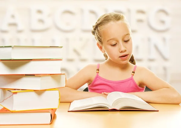 Weinig schoolmeisje lezen van een boek — Stockfoto