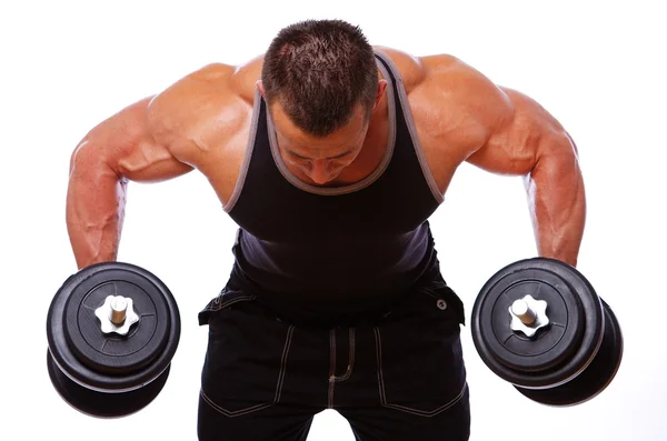 Portret van sterke man poseren in gym met dumbbels — Stockfoto