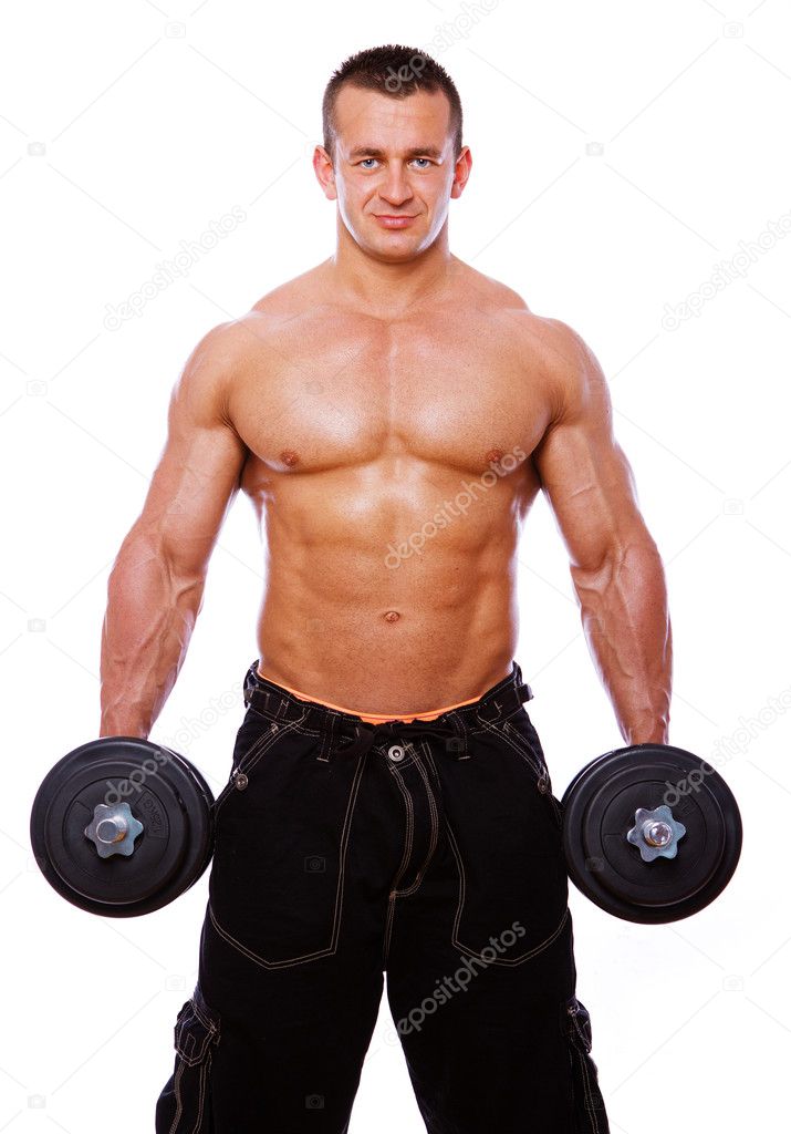 Portrait of strong man posing in gym with dumbbels
