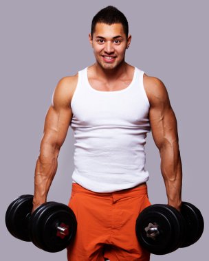 Fit muscular man exercising with dumbbells clipart