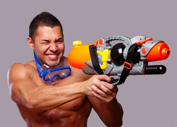 Hombre musculoso con pistola de agua y con equipos de natación —  Fotos de Stock