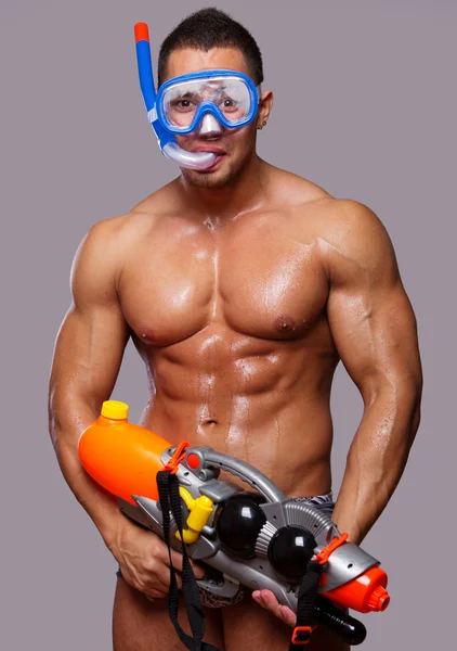 Kaslı adam ekipmanları yüzme ve su tabancası ile — Stok fotoğraf