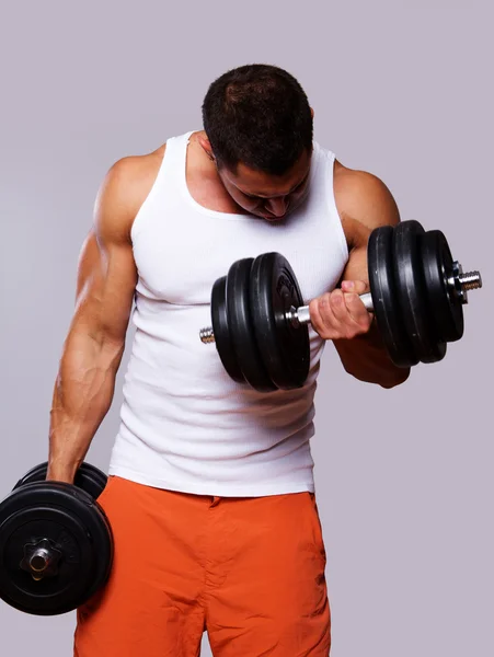 Ajuste hombre musculoso ejercicio con mancuernas — Foto de Stock
