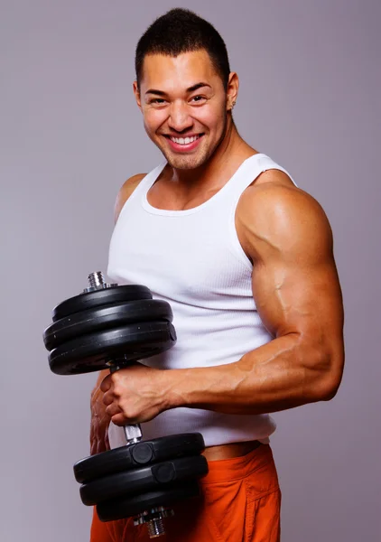 Porträt eines jungen Mannes, der Gewichte stemmt — Stockfoto